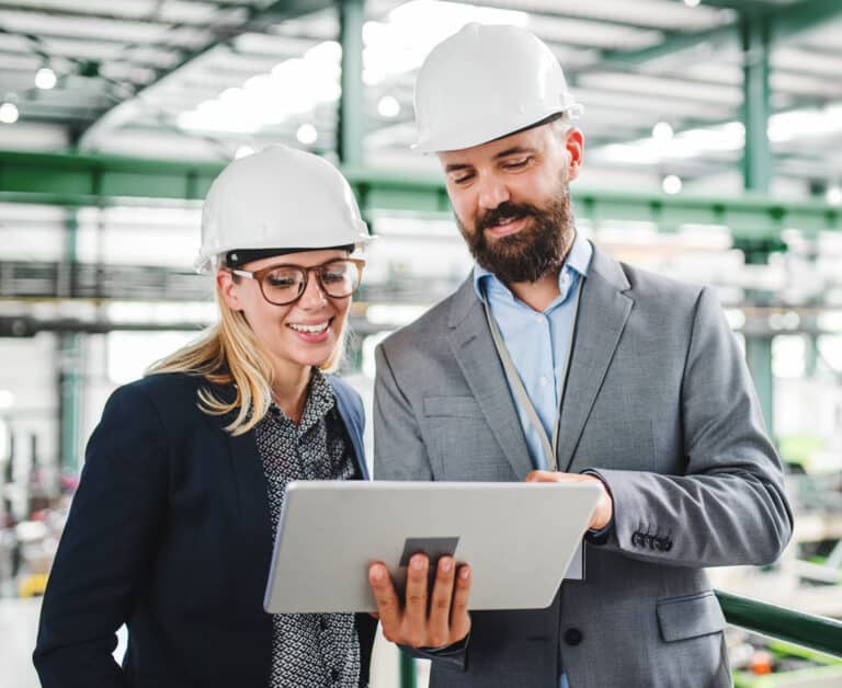 Industrial man and woman engineer with tablet in a factory