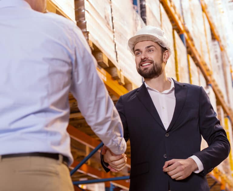 Businessmen shaking hands while meeting each other in the storehouse